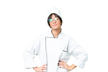 Young caucasian chef  woman over isolated chroma key background posing with arms at hip and smiling