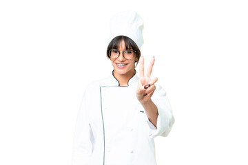 Young caucasian chef  woman over isolated chroma key background smiling and showing victory sign