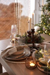 Christmas place setting with festive decor on wooden table in room