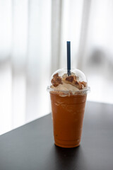 Thai Tea Blended with whipped cream, on the table with blurred background