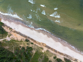 Coast of the Baltic Sea, waves rolling along the sandy shore, view from above.