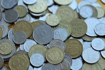 Metal coins of Ukraine of different denominations are scattered. Money texture, business background.