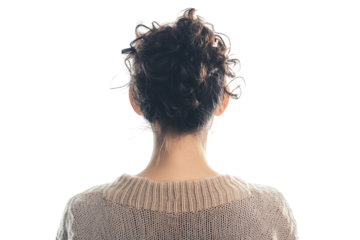 A woman with curly hair, facing away from the camera, embodies a moment of introspection, radiating a sense of calm and tranquility in her surroundings.