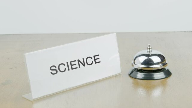 Science Office or Room with Hand Ringing The Bell on Desk or Table Multiple Times