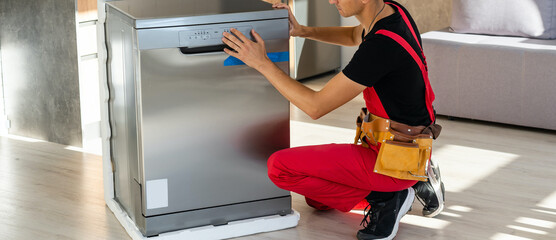 Worker repair dishwasher at home.
