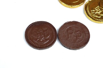 Indonesian chocolate coin candy or chocolate coin candy with garuda bird symbol and rupiah currency isolated on white