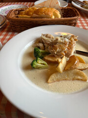 チキンとのクリーム煮とパンがのっている食卓
