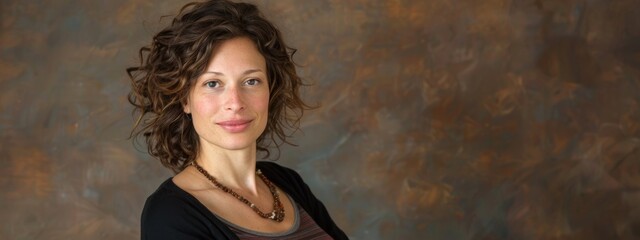Fototapeta premium Woman with curly hair is standing in front of a wall