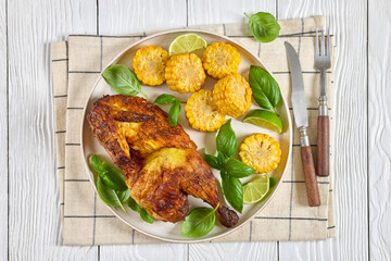 half of bbq chicken with corn cobs coins and basil