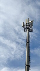 Obraz premium Mobile data tower with antennas against a blue sky. The concept of telecommunication equipment, high-speed mobile communication. High quality photos