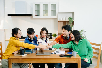 Teamwork and creativity with young adults collaborating on laptops and tablets in a cozy