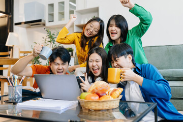 Happy group of college students use laptop feel excited overjoyed triumph with good news over smartphone or Tablet.