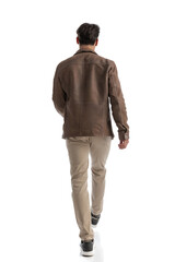 back view of fashion man in leather jacket walking