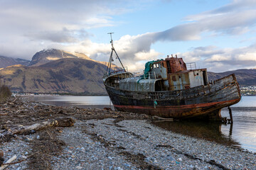 Fototapeta premium Das Wrack Old Boat of Caol Shipwreck und der Berg Ben Nevis am Loch Eil bei Fort William in Schottland