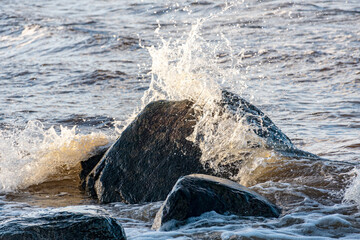 Fototapeta premium landscape with the seashore, windy winter day, water splashes, icy stones on the seashore, Baltic Sea, Latvia