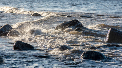 landscape with the seashore, windy winter day, water splashes, icy stones on the seashore, Baltic...