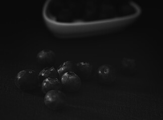 A bowl of blueberries is on a black background