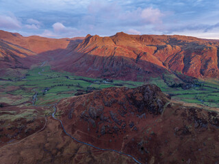 Beautiful aerial drone landscape image of Blea Tarn and Langdale Valley in Lake District during vibrant Autumn sunrise