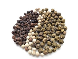 Dark, white and green pepper seeds on a white background.