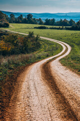 Bending dirty road landscape in autumn