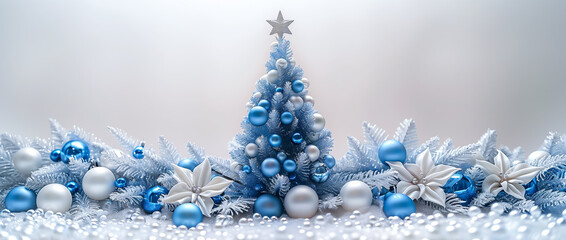 A miniature blue Christmas tree surrounded by festive ornaments and snow, creating a winter wonderland scene.