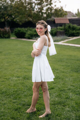 Obraz premium Cute girl in a white dress on a garden background