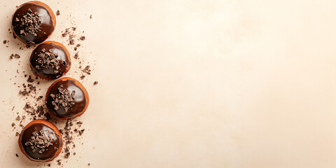 Chocolate donuts on a beige mocha mousse background. Design concept banner of romantic, sweet life,confectionery, Valentine's day, chocoholic style and weight loss and healthy eating with copyspace