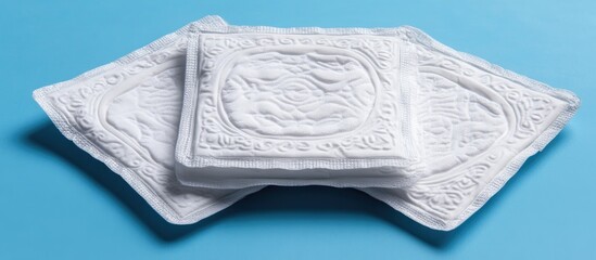 Three individually wrapped sanitary napkins displayed neatly