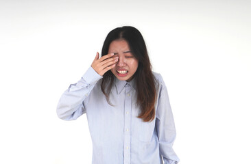 Asian women with light blue shirt and long hair having an sore eye irritation. Indonesian girl with...
