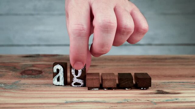 AGENDA. Spelling word using wooden alphabet blocks