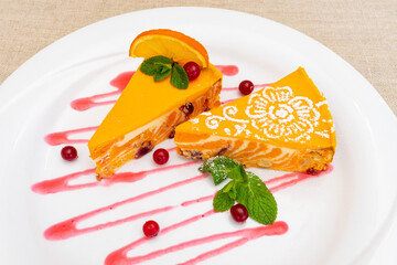 Colorful orange dessert served on a plate with berries and mint