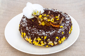 Chocolate cake with coconut and fruit slices on a plate