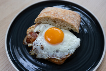 A plate of bacon and egg sandwich.