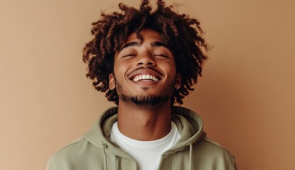 Obraz premium Joyful young man with afro smiling against beige backdrop