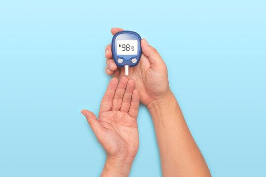 Person holding a blue blood sugar monitor