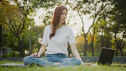 Young woman practicing yoga, Online video training, watching video online tutorials on laptop,...