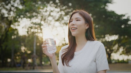 Asian Woman drinking bottle of water. Slim and fit woman, Healthy Lifestyle. Morning of beautiful...