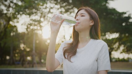 Asian Woman drinking bottle of water. Slim and fit woman, Healthy Lifestyle. Morning of beautiful...