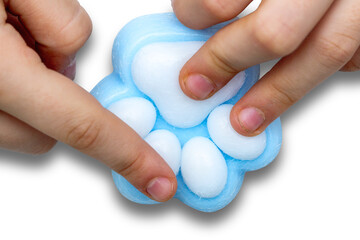 Little girls hands pressing and playing with new Taba paw blue colorful toy antistress squish isolated on white background