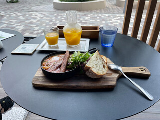 オレンジジュースとソーセージとパンの朝食