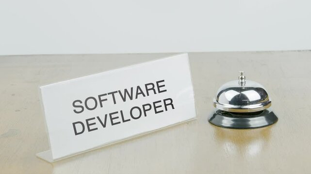 Software Developer Office or Room with Hand Ringing The Bell on Desk or Table Multiple Times