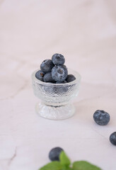 Fresh blueberries in a crystal bowl on a marble table