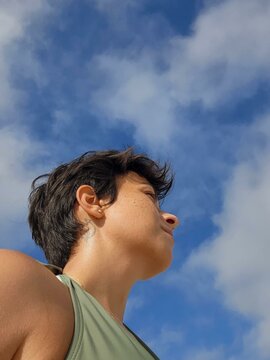ovem Woman with short, dark hair looking at the horizon with a serious expression.