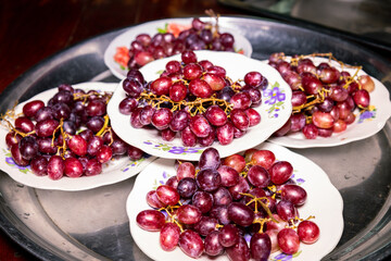 The red and purple grapes on a plate are ready to eat Sweet and sour taste for good health, taken in Myanmar.