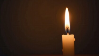 Single candle flickering in silence honoring those affected by cancer.