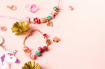 Charm Bracelets with Vibrant Beads on Soft Pink Background.Decorative Beaded Jewelry with Heart and...