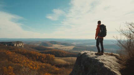 Male Hiker Standing on Cliff Overlooking Autumn Landscape
