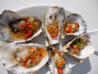 Steamed oysters with vegetables in the shells.