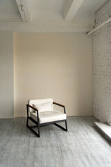 White soft designer armchair in a loft room