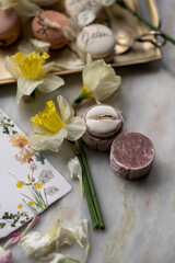 Velvet ring box with golden band surrounded by spring flowers